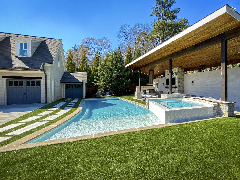 Backyard pool area landscaping featuring ForeverLawn synthetic grass
