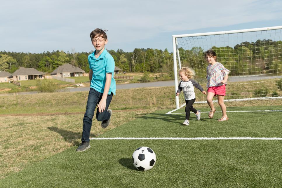 Watkins son playing on backyard soccer field featuring SportsGrass by ForeverLawn on America's Most Desperate Landscape